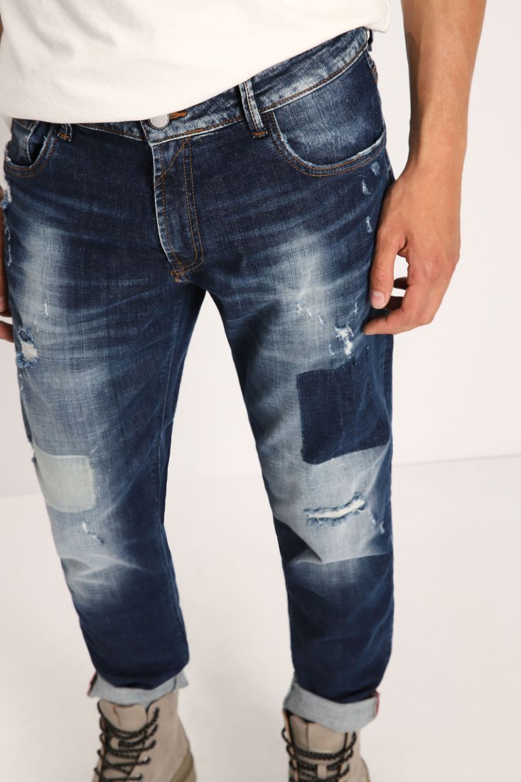 Jeans slim-fit con abrasioni e orli risvoltati